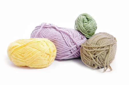 Four balls of woollen yarn on white background 
