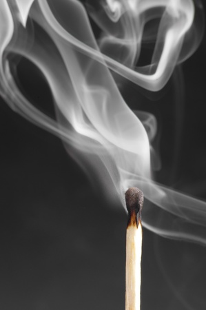 Smoke from a match that was just put out, on the black background の写真素材