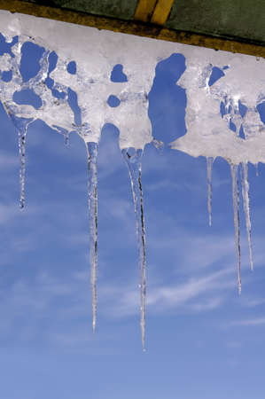 Icicles against partly cloudy skies