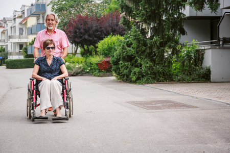 Senior Couple In Wheelchair, Enjoying A Day In The Cityの写真素材