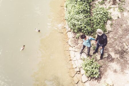 Senior Couple Looking At Ducks Swimming In Neckar Riverの写真素材