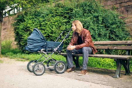 Young Father With Baby Stroller In The Parkの写真素材