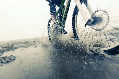 Mountain Biker Racing Through Puddleの写真素材
