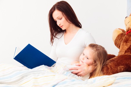 Mother Reading A Story To Her Daughterの写真素材