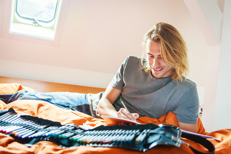 Young Man On Bed, Drawing In Coloring Bookの写真素材