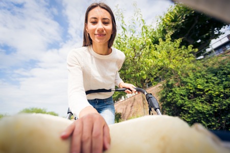 Young Mother Looking At Her Baby In A Strollerの写真素材