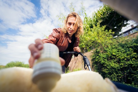 Young Father Looking At His Baby In A Strollerの写真素材