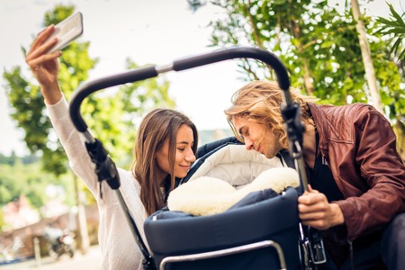 Young Parents Taking Selfies With Their Newborn Babyの写真素材