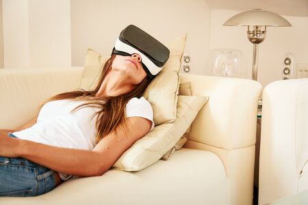 Young Woman Sitting On Couch, Using Vr Glasses