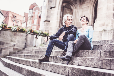 Senior Couple Taking A Rest Next To Churchの写真素材