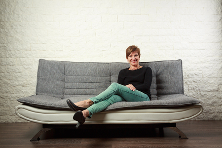 Senior Woman Sitting On Couchの写真素材