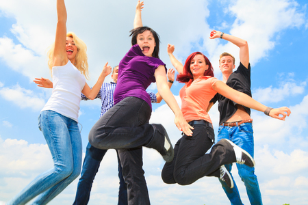 Young People Jumping In Front Of Blue Skyの写真素材