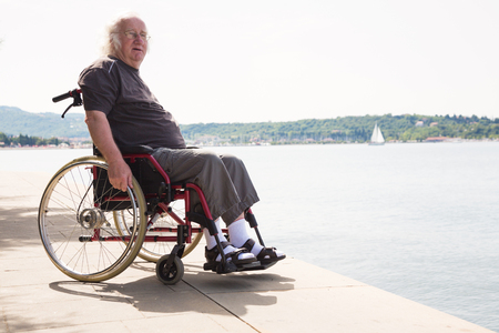 Happy Old Man In Wheelchair Looking At The Seaの写真素材