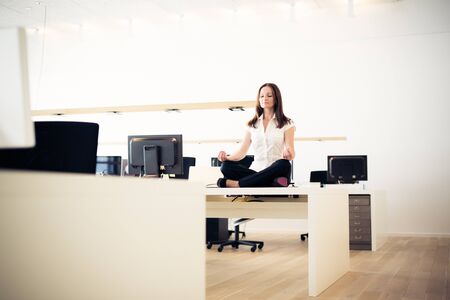 Businesswoman Doing Yoga At The Officeの写真素材