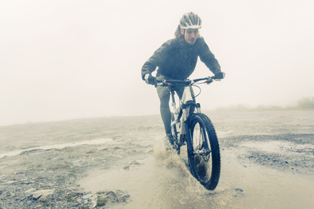 Mountain Biker Racing Through Puddleの写真素材