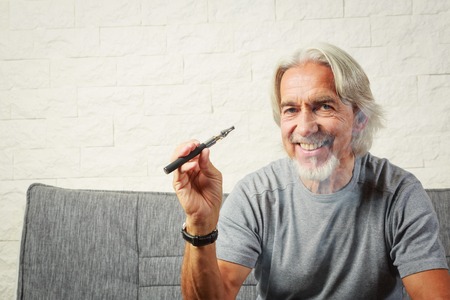 Senior Vaping, Enjoying An Electronic Cigaretteの写真素材