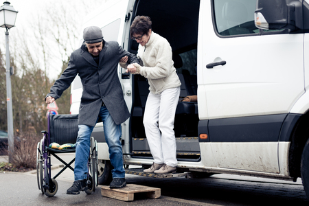 Nurse Helping Senior Man Exit A Vanの写真素材