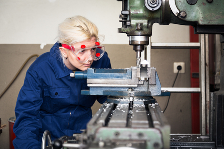 young mechanic apprentice working on milling machineの写真素材