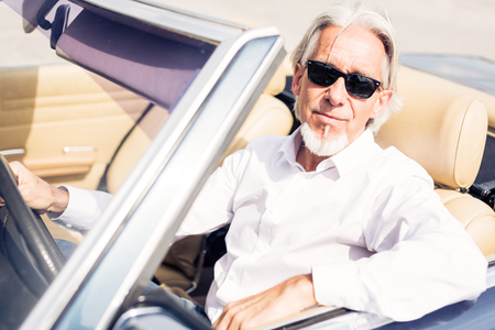 Senior Man Driving A Convertible Classic Carの写真素材