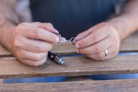 Man Filling Liquid Into His Electronic Cigaretteの写真素材