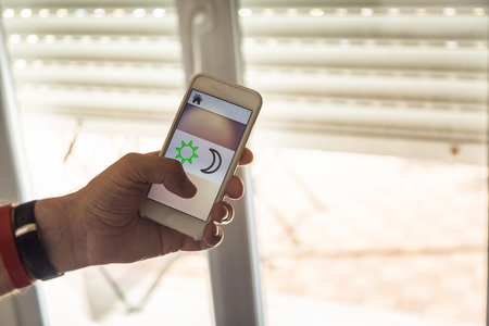 Smart Home: Man Controlling Blinds With His Phoneの写真素材