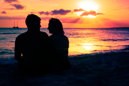 Young Couple Enjoying Sunset By The Beachの写真素材