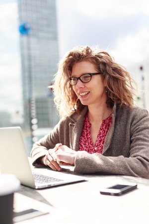 Businesswoman Sitting Outdoors, Working On Her Computerの写真素材