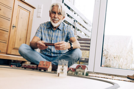 Senior Man Playing With Model Trainの写真素材