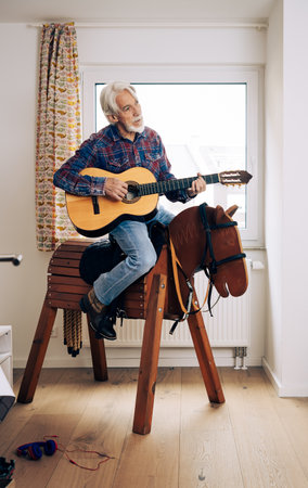 Senior Man Playing Cowboy With Toy Horseの写真素材