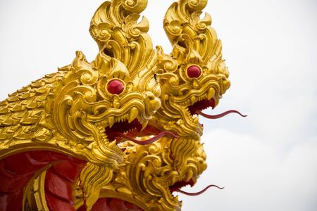 The three golden serpent head or king of naga statue on white sky.の写真素材
