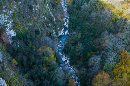 River flowing in the forest. Aerial view. Big stones and colorfull treesの写真素材