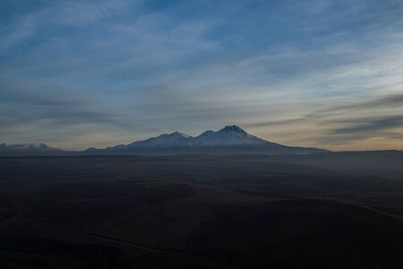 Snowy Mount Hasan. Volcano in Aksaray Turkey, Anatolia. Sunset. Pink Red Orange skyの写真素材