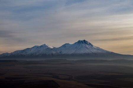 Snowy Mount Hasan. Volcano in Aksaray Turkey, Anatolia. Sunset. Pink Red Orange sky
