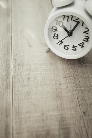 alarm clock on wood table in vintage color style