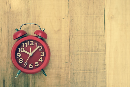 alarm clock on wood table in vintage color style