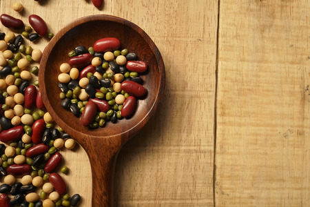 beans and a wooden spoon on the old wood tableの写真素材