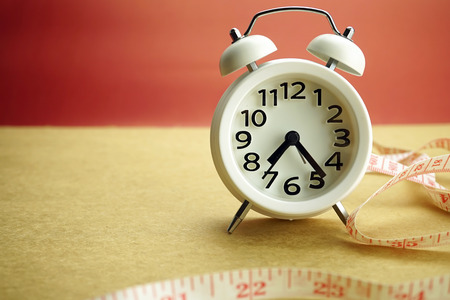 alarm and Measuring tape diet concept