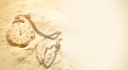 vintage pocket watch on sandの写真素材