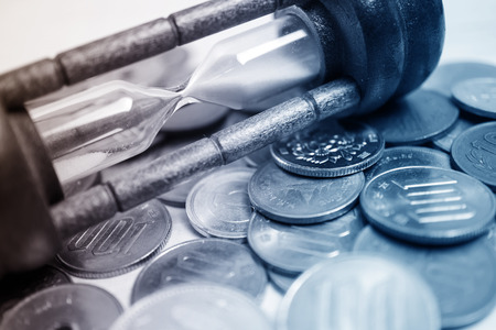 coin money and hourglass for money concept
