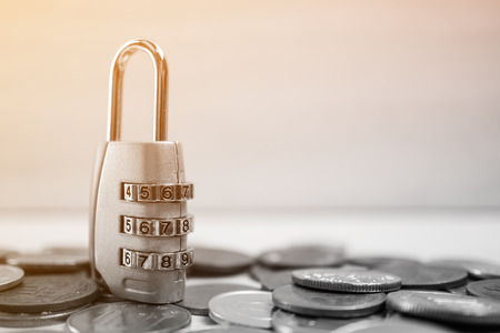 combination padlock on coin money for financial security conceptの写真素材