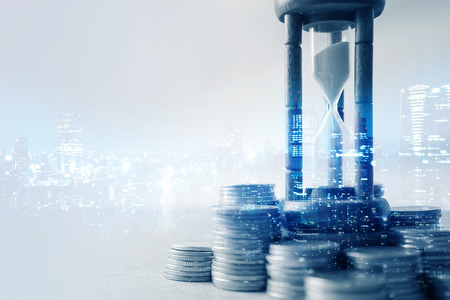 Double exposure of coin money and hourglass for about time of finance conceptの写真素材