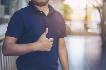 The man hand in closeup showing thumb up or like gesture as excellent and successful job concept