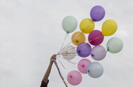 Girl hand holding colorful balloonsの写真素材