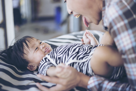 Beautiful Mother And Baby outdoors. Happy family. Beauty Mum and her Child playing at homeの写真素材