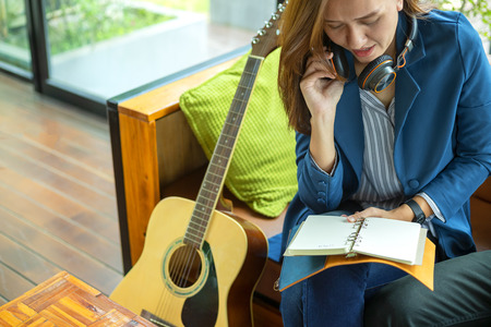 Beautiful girl is playing guitar by the window. Education lifestyle relax conceptの写真素材
