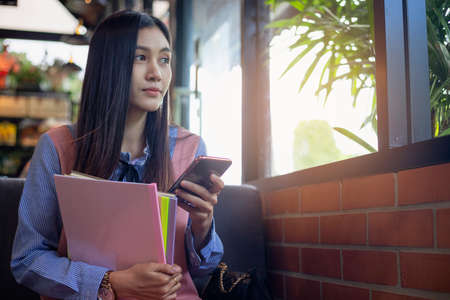 Portrait of focused woman is focused on jotting down important information of the person in preparation for the entrance exam. Getting ready for a professional startの写真素材