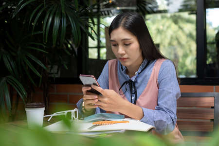 Portrait of focused woman is focused on jotting down important information of the person in preparation for the entrance exam. Getting ready for a professional startの写真素材