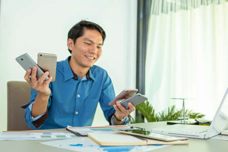 Asian woman wearing headphones using laptop sitting in her bedroom to communicate with friends during the epidemic of COVID-19の写真素材