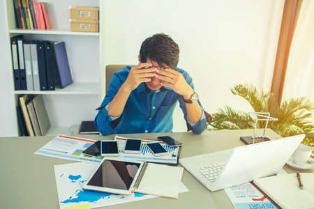 Asian woman wearing headphones using laptop sitting in her bedroom to communicate with friends during the epidemic of COVID-19の写真素材