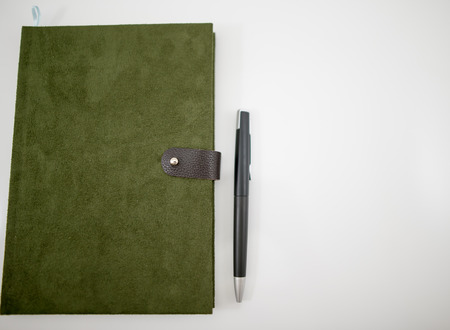 Notebook green velvet with a black pen.の写真素材